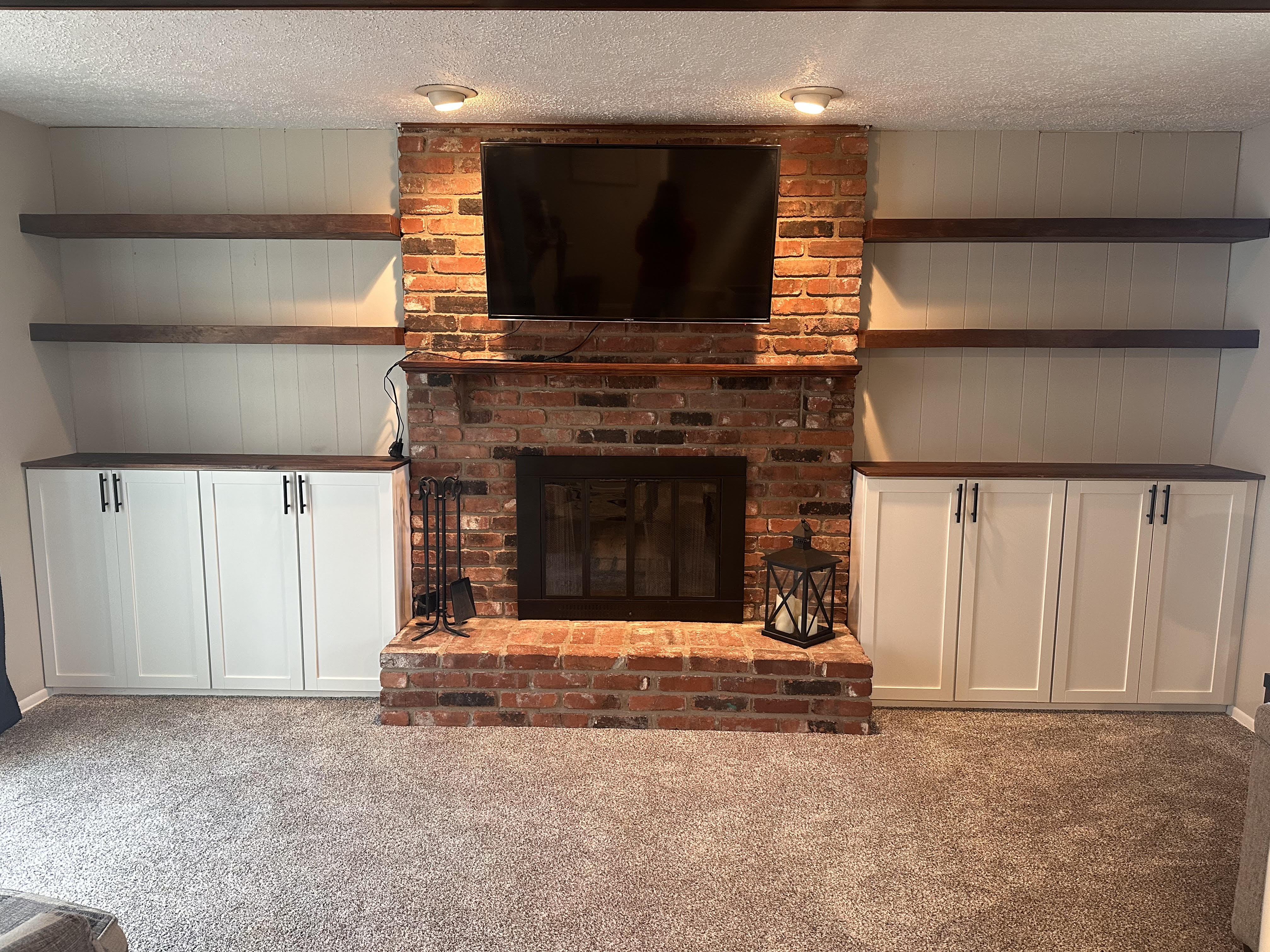 Remodeled home fireplace with shelves and cabinents.